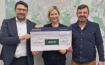(v.l.n.r.) Andreas Schneider, stv. Gesch&auml;ftsf&uuml;hrer der AOK Mittlerer Oberrhein, &uuml;bergibt Spenden-Scheck an Karlsruher B&uuml;rgermeisterin Yvette Melchien und Beauftragten f&uuml;r Suchtpr&auml;vention Philipp Weber 
