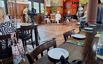 Baden-TV: Gender-Medizin Momentaufnahme der Podiumsdiskussion zum Thema Gender-Meizin: Vier Personen sitzen nebeneinander. Im Vordergrund stehen Tische für das Publikum.