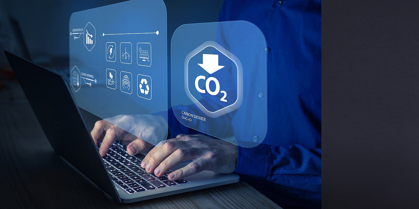 Foto: Person sitzt vor Rechner und schaut eine CO₂-Bilanz an