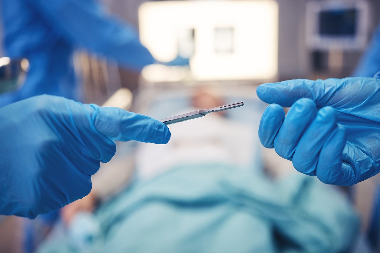 Foto zeigt eine laufende Operation, bei der ein Instrument an den Operateur gereicht wird.