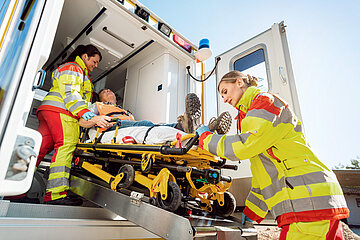 Zwei Sanit&auml;terinnen transportieren einen Verletzten in den Rettungswagen.