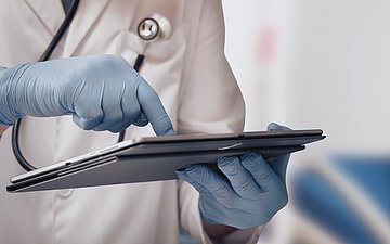 Dokumentation Foto: Hand von einem Arzt zeigt auf eine Kladde