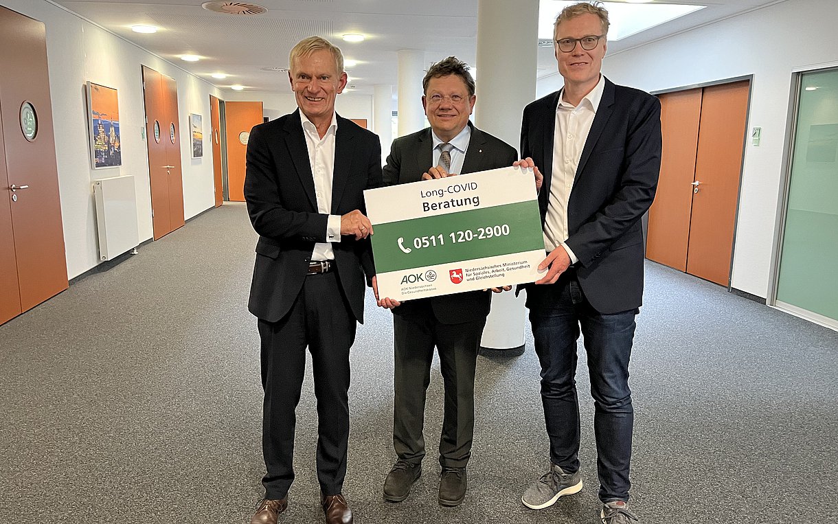 Foto: Dr. Jürgen Peter (AOK Niedersachsen), Dr. Andreas Philippi (Niedersächsisches Ministerium für Soziales, Arbeit, Gesundheit und Gleichstellung), Prof. Dr. Nils Schneider (Medizinische Hochschule Hannover) stehen gemeinsam in einer Halle 