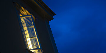 Foto eines beleuchteten Fensters bei Nacht