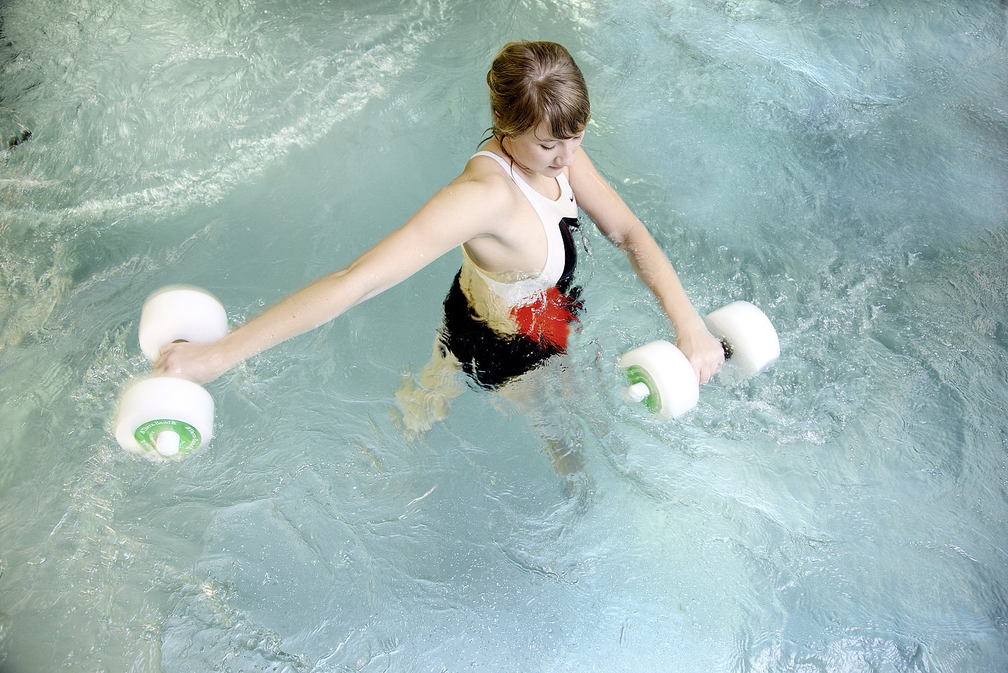 Eine junge Frau befindet sich während der Physiotherapie im Wasser.