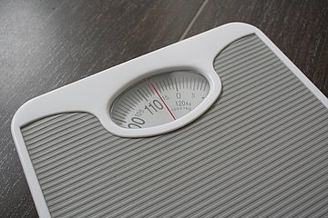 Badezimmerwaage Eine Badezimmerwaage zeigt hundert Kilogramm an.