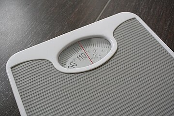 Eine Badezimmerwaage zeigt hundert Kilogramm an.