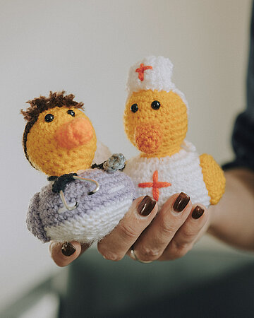 Diana Stolz h&auml;lt zwei geh&auml;kelte Quietscheenten in die Luft.