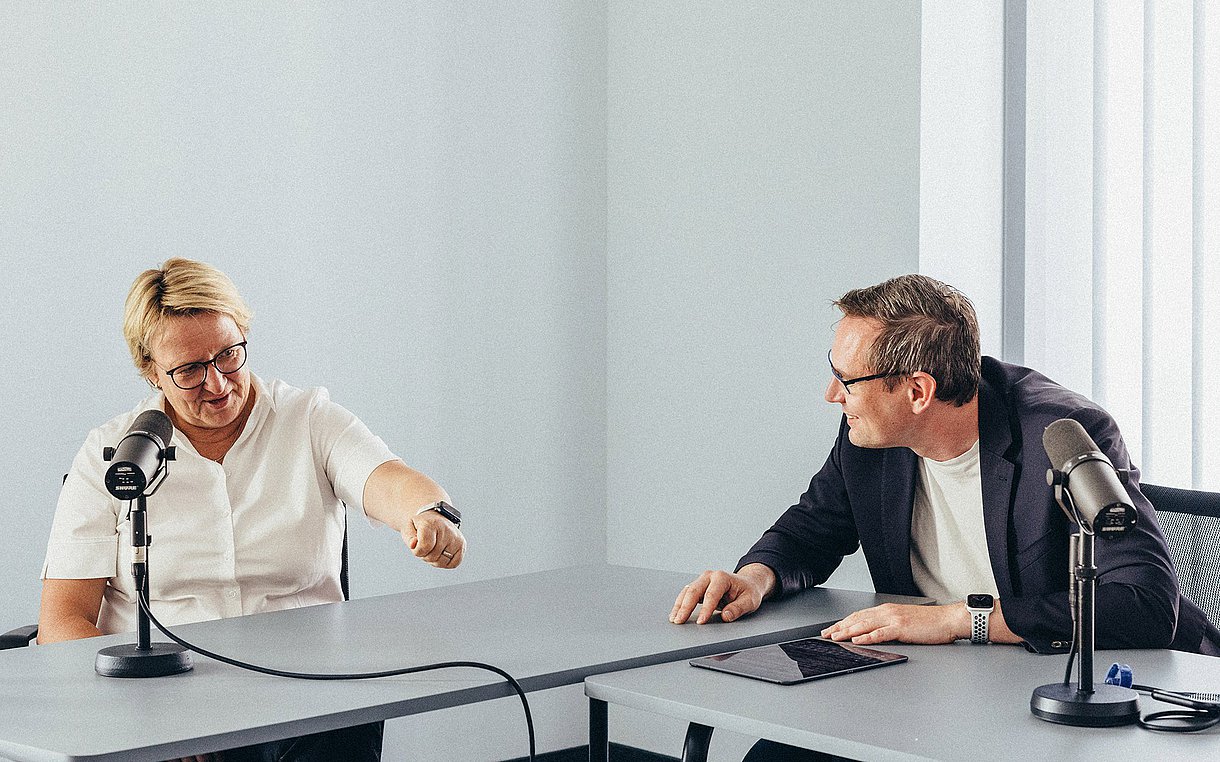 Foto von Sylvia Thun und Kornell Adolph, wie sie an einem Konferenztisch diskutieren