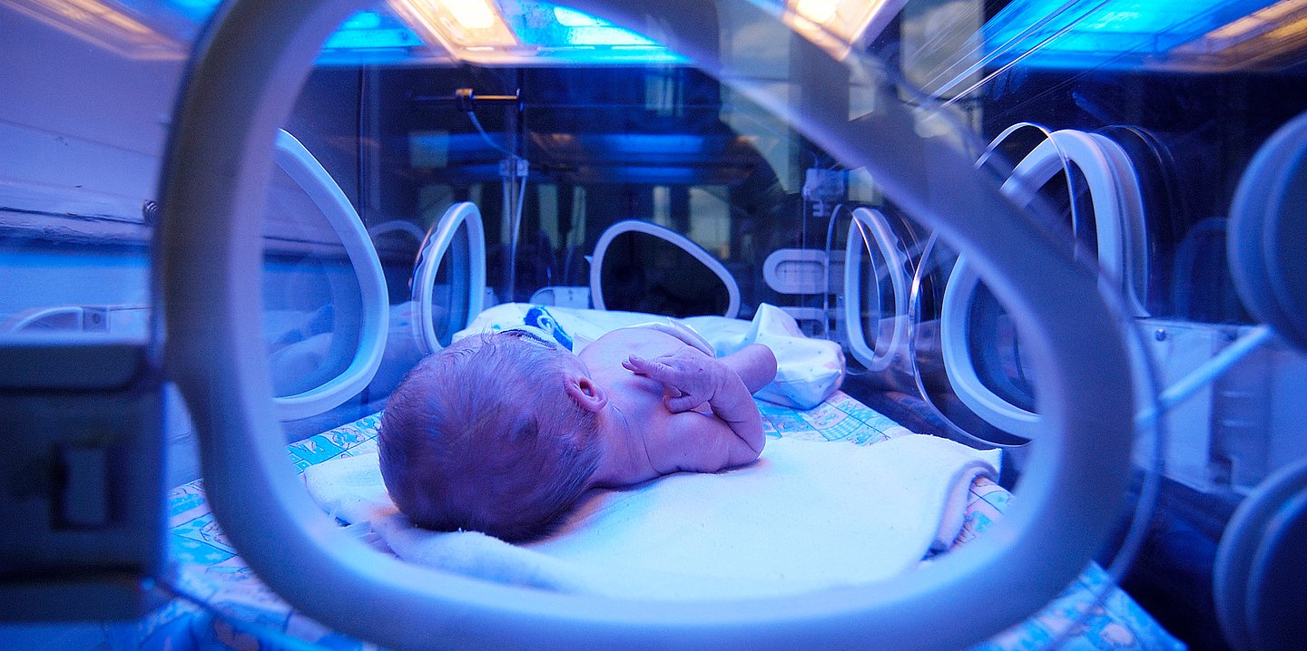 Foto: Ein frühgeborenes Baby liegt in einem Brutkasten.