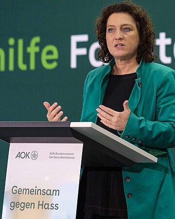 Carola Reimann am Rednerpult, im Hintergrund steht auf einer gr&uuml;nen Wand in wei&szlig;er Schrift: Selbsthilfe-Fachtagung.