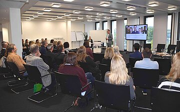 Ein von hinten zu sehendes Publikum verfolgt das Podiumsgeschehen beim Arbeitgeberforum.