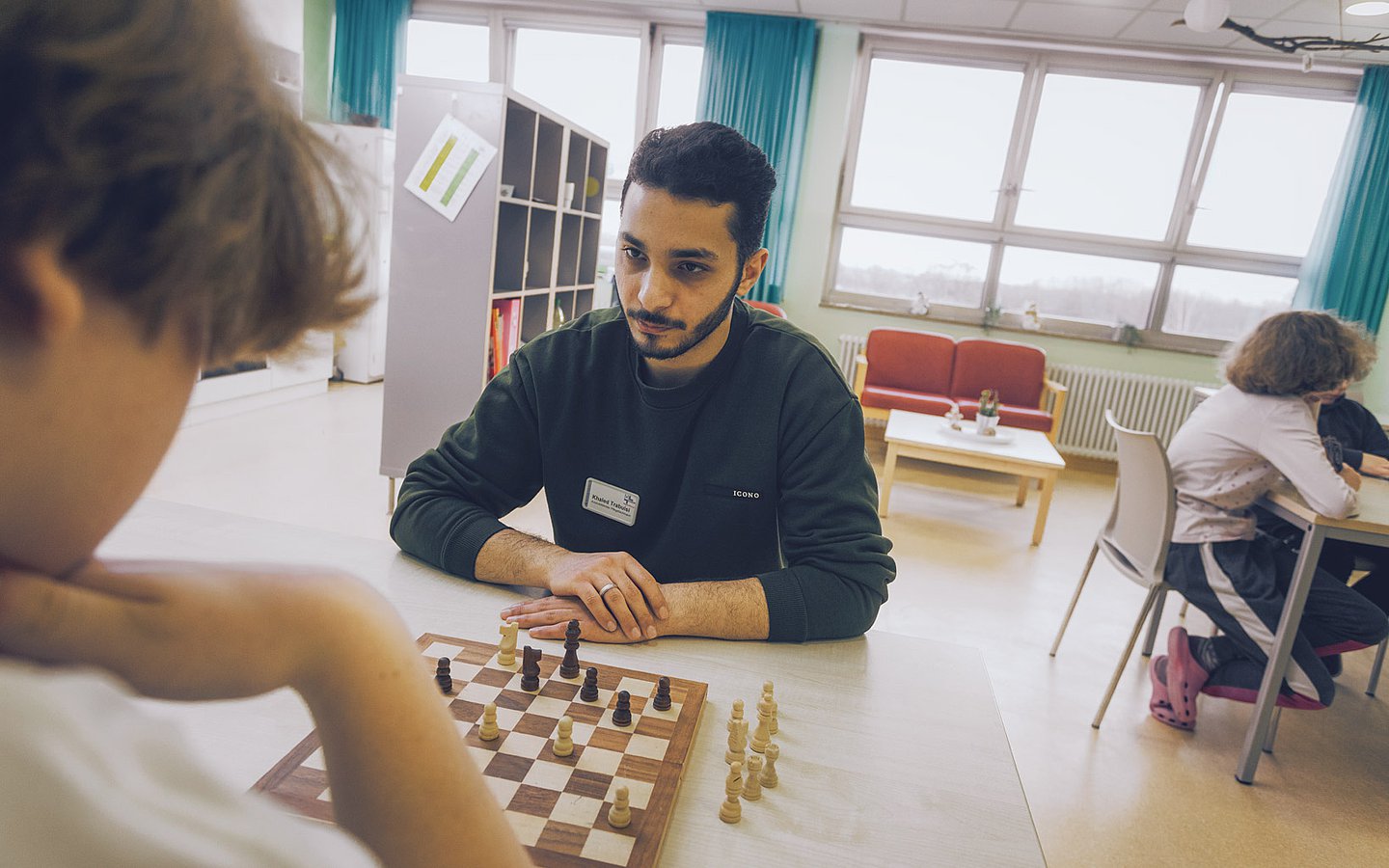 Foto von Pfleger Khaled, wie ein mit einem Patienten Schach spielt
