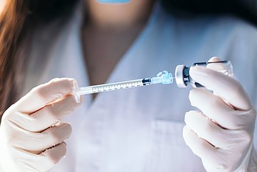 Grippe-Fazit für Schleswig-Holstein Eine Ärztin zieht eine Spritze in Großaufnahme auf.