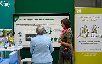 Zwei Personen schauen auf einem Bildschirm mit der &Uuml;berschrift "Was ist besonders an diesem Projekt?"