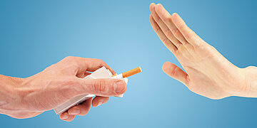 Foto einer Hand, die einer anderen Hand eine weiße Schachtel hinhält, aus der eine Zigarette stakst. Die andere Hand wehrt ab.