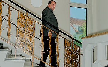 Foto von Gesundheitsminister Magnus Jung, der eine edle Treppe herunterl&auml;uft
