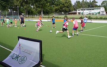 Eine Fu&szlig;ballszene mit einem Mini-Tor im Vordergrund.