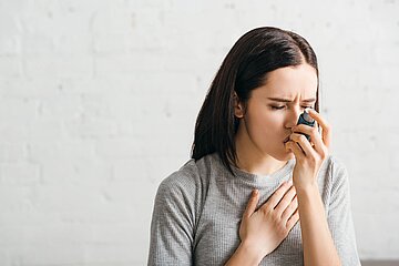 Schmuckbild zeigt Frau bei Bedienung eines Dosieraerosols