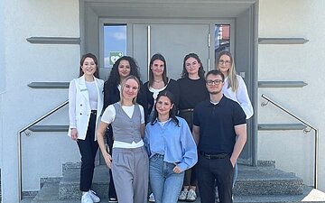 Auszubildende stehen vor einem KundenCenter