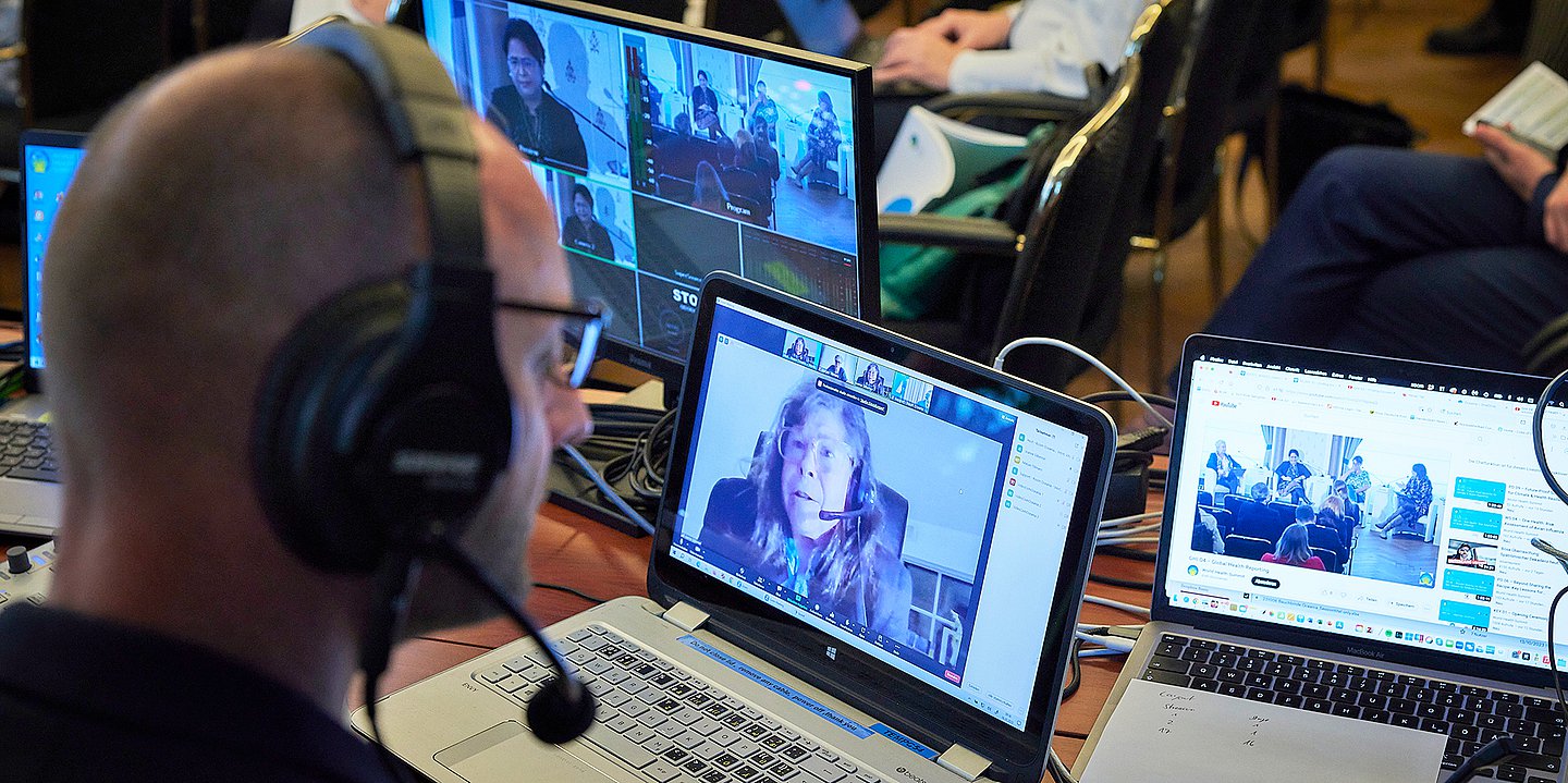 Foto von Journalisten, die den World Health Summit mit Kopfhörern mitverfolgen.