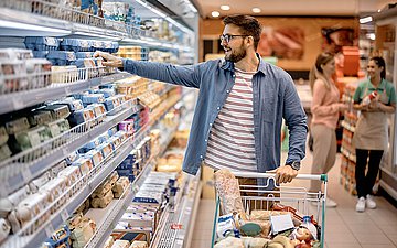 Verbraucher Foto: Mann greift Ware aus dem Kühlregal im Supermarkt