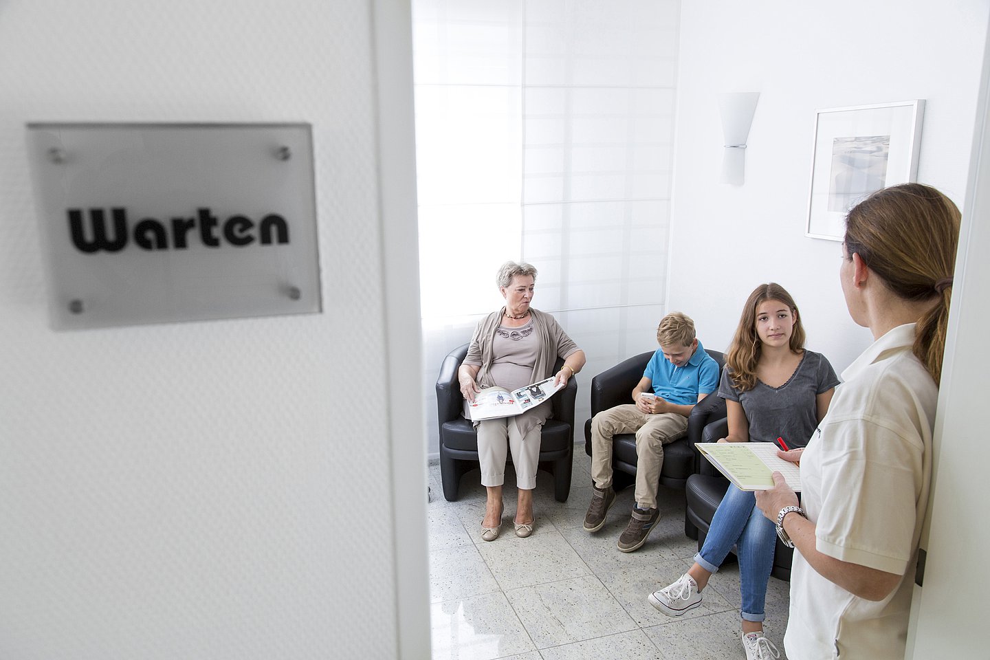 Foto: Eine Medizinische Fachangestellte ruft eine Patientin auf.