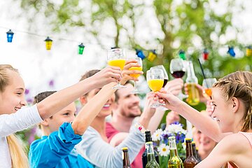 Fr&ouml;hliche Menschen erheben ihre Gl&auml;ser bei einem Nachbarschaftsfest