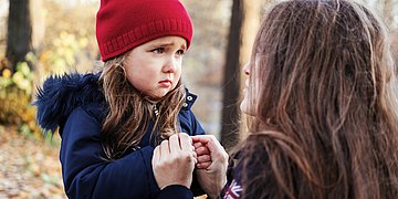 Kind mit Angst Foto: Ein kleines Mädchen schaut ängstlich, die Mutter spricht ihr Mut zu.