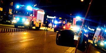 Foto: Auf einer Stra&szlig;e stehen mehrere Rettungswagen mit Blaulicht.
