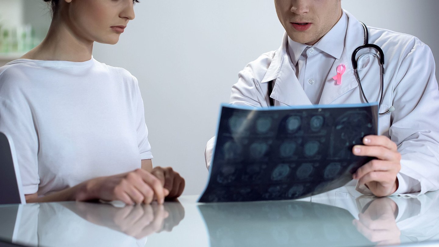 Foto: Ein Arzt zeigt seiner Patientin ihre Röntgenbilder.