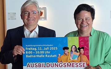 Ausbildungsmesse Mittelbaden 2025 Ulrich Kistner und Petra Spitzmüller halten gemeinsam ein Plakat der Ausbildungsmesse Mittelbaden in die Kamera.