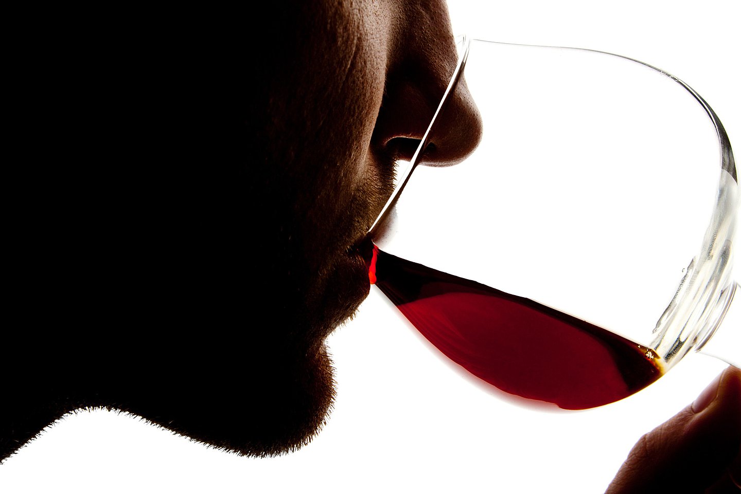 Ein Mann trinkt ein Glas Rotwein.
