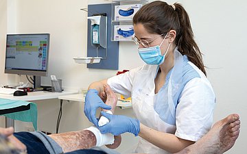 Melanie Korneck bei der Therapie. Foto: Arzthelferin verbindet Fuß
