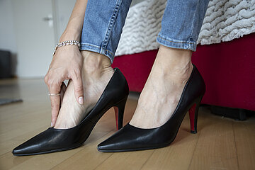 Eine Person in High Heels reibt sich ihren Fu&szlig;.