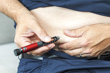 Eine &auml;ltere Person injiziert sich Insulin in den Bauch.