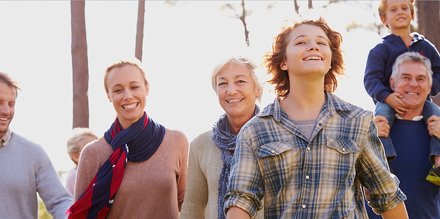 Foto: Mehrere Menschen, jung und alt, laufen nebeneinander und lachen.