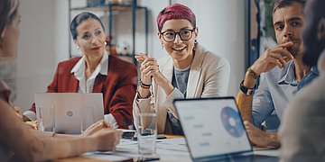 Diversity-Tag Foto: Mehrere Personen sitzen in einem Arbeitsmeeeting und unterhalten sich