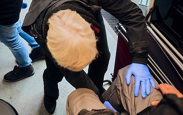 Dr. Burkhardt untersucht das Bein eines Patienten. 