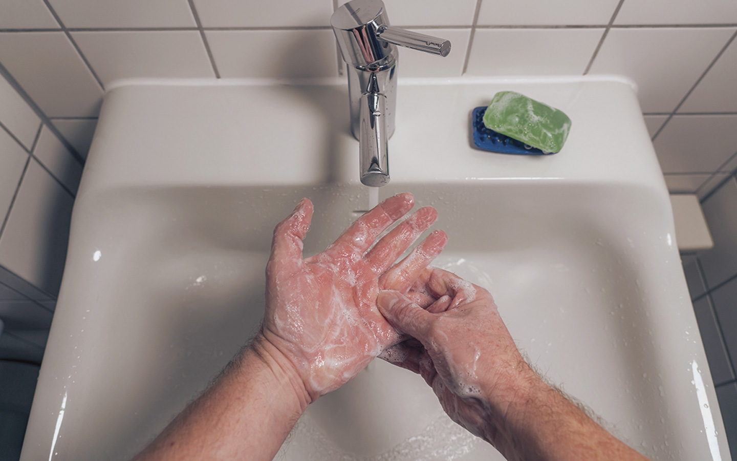Foto: Zwei Hände beim Waschen am Waschbecken.
