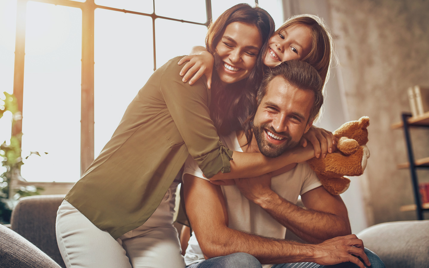 Foto: Mann, Frau und Kind umarmen sich.