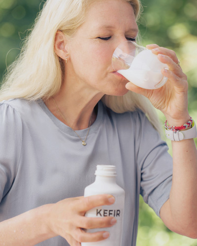 Foto: Frau trinkt ein Glas Kefir.