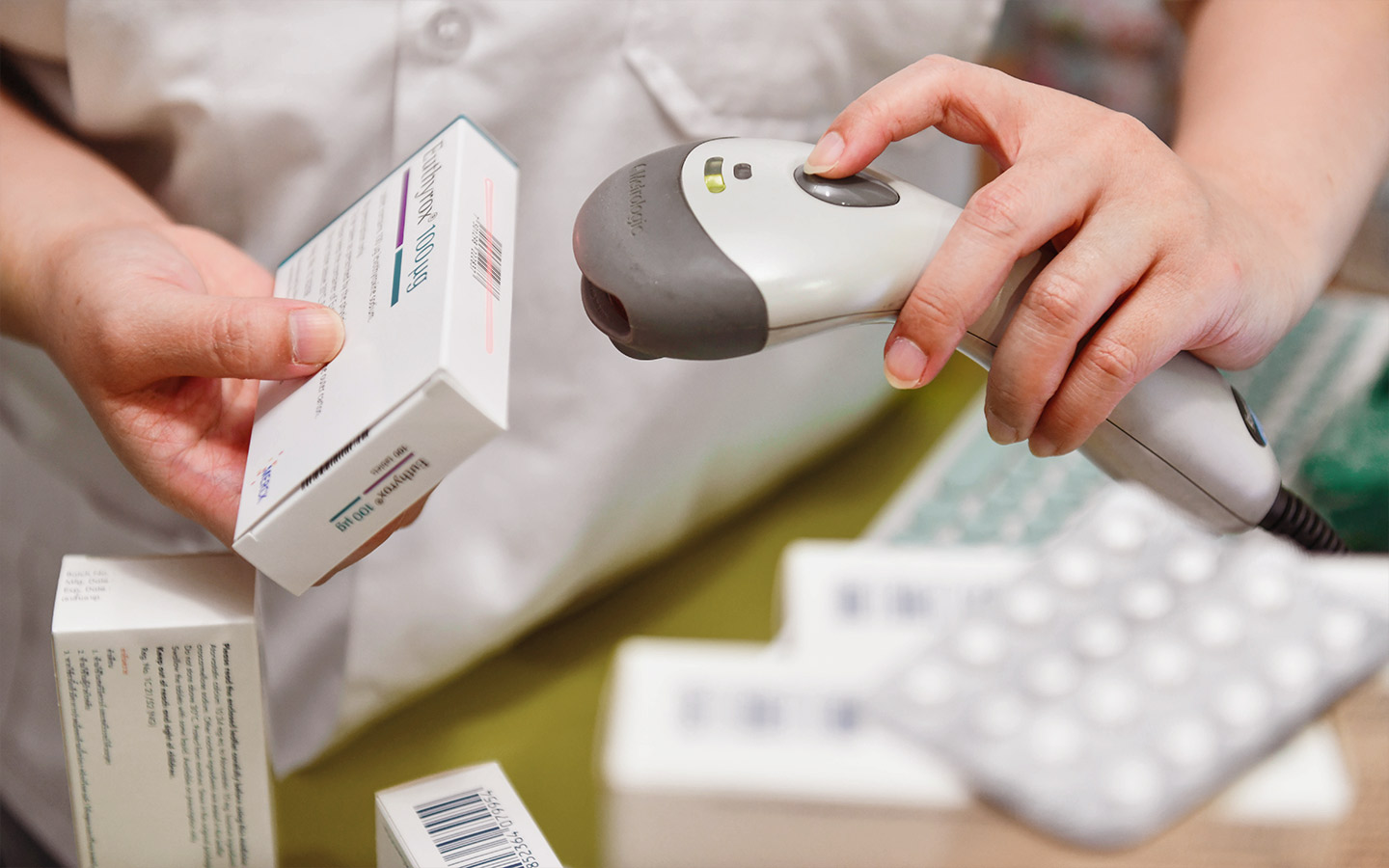 Foto von Arzneimitteln, die gerade in der Apotheke an der Kasse gescannt werden.