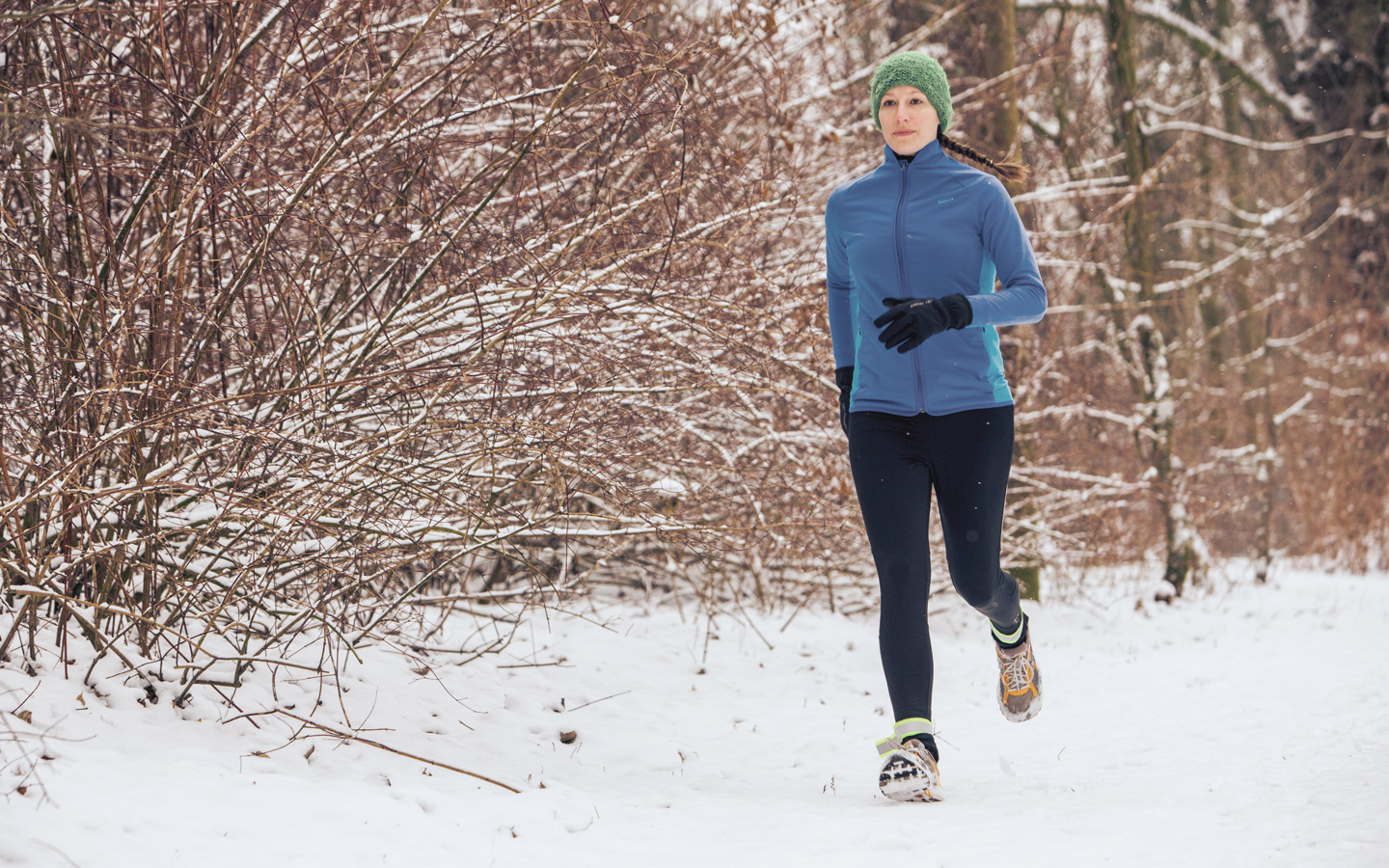 Foto: Eine Frau joggt durch den Schnee.